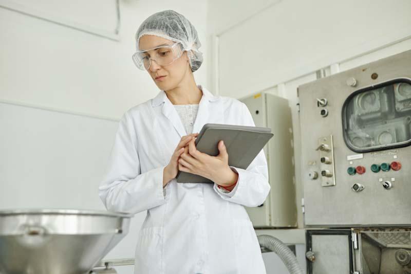 An inspector works to complete a food safety inspection on their tablet using software like the 1st Reporting app. Learn more at 1stReporting.com.