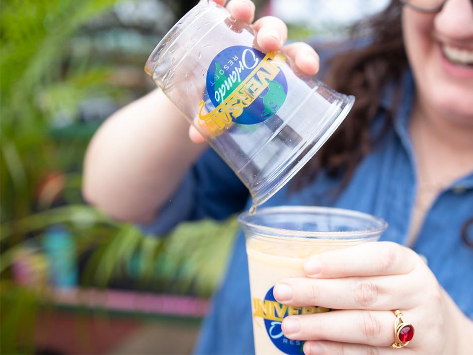 A person pouring a drink into a cup