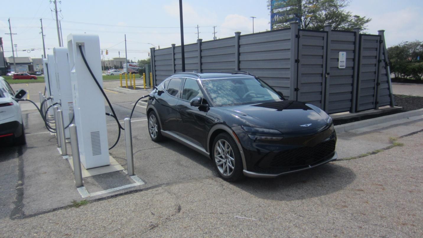 A black car at a charging station

Description automatically generated