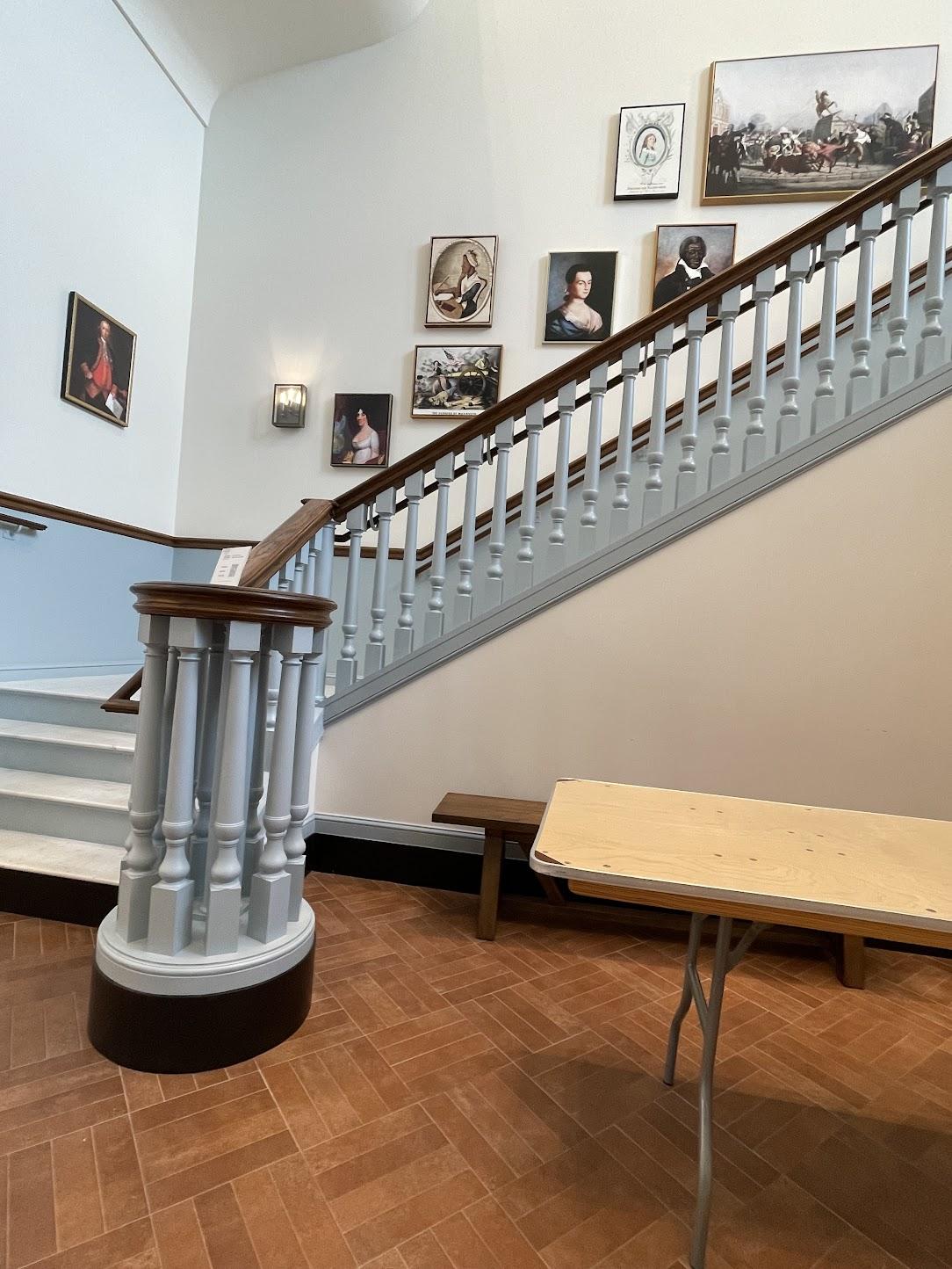A staircase with a table and a bench

Description automatically generated