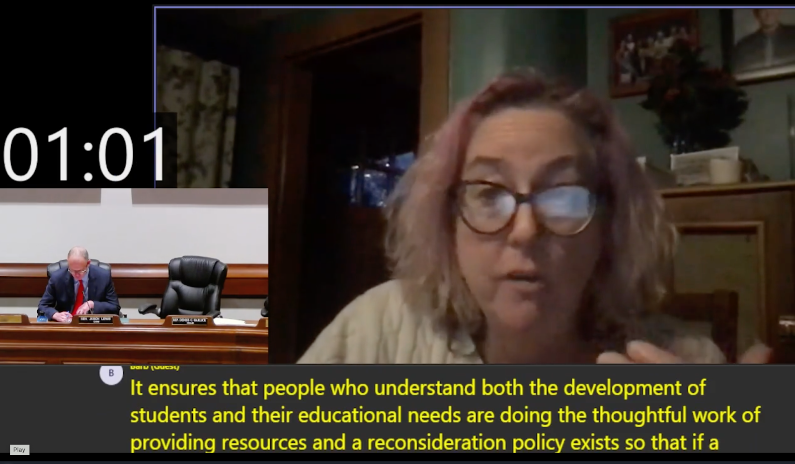 a still from the video of Barb giving testimony to the MA Legislature hearing; she is videoconferencing from what looks like her home, and there is a man (presumably a legislator) in an inset video window looking down at notes; captioning says, "It ensures that people who understand both the development of students and their educational needs are doing the thoughtful work of providing resources and a reconsideration policy exists so that if a"