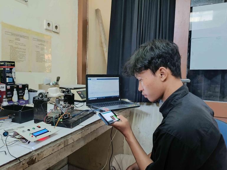 M. Kurniawan berfoto dengan inovasi Alat Momen Tekuk Fitting Lampu. Sumber gambar : dokpri