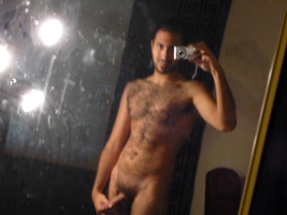 blurry mirror selfie taken with a digital camera of naked hairy otter male showing off his flaccid cock