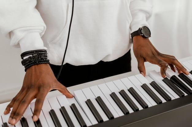 High angle of male musician playing electric keyboard