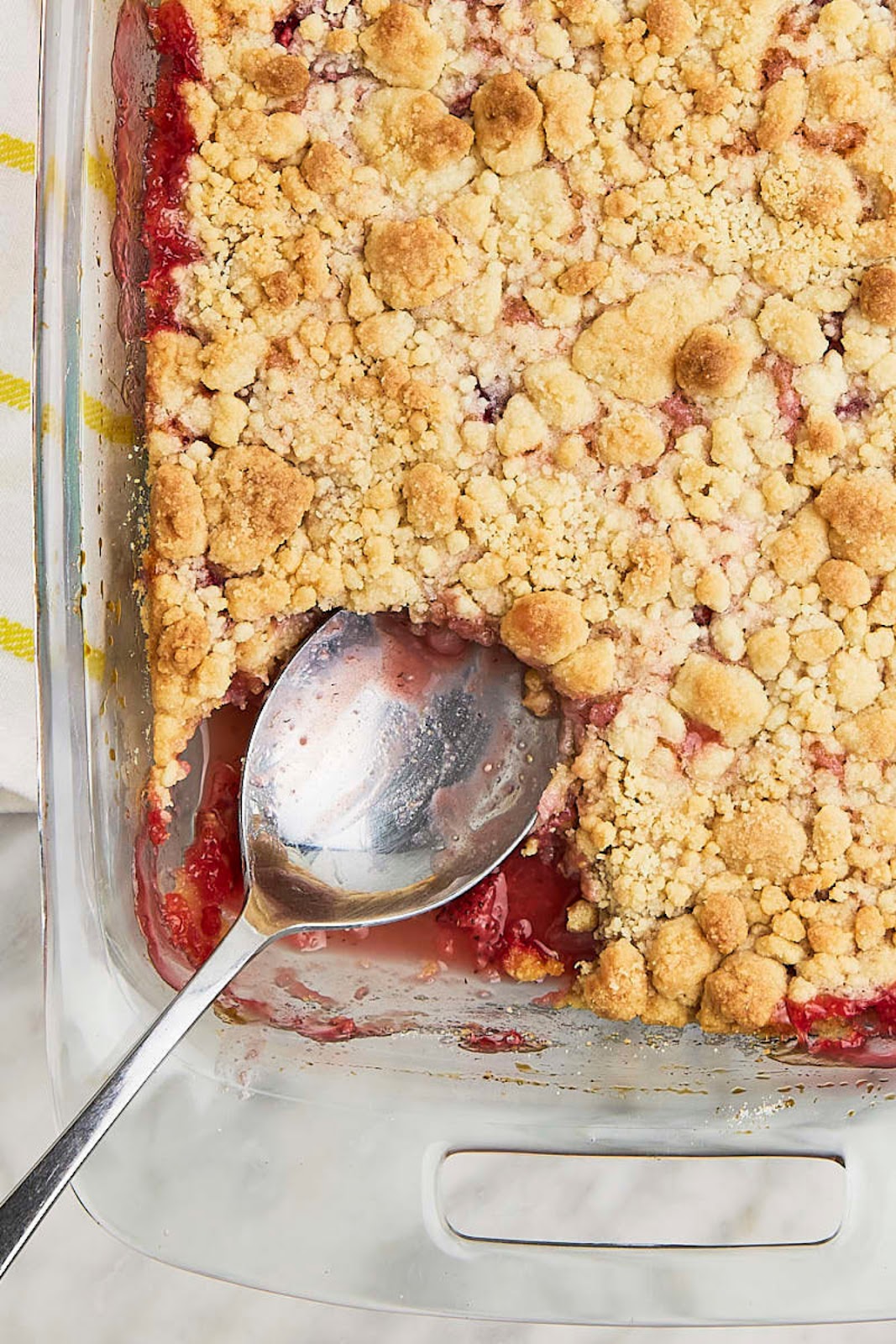 A glass dish with a scoop of cranberry crumble dump cake.