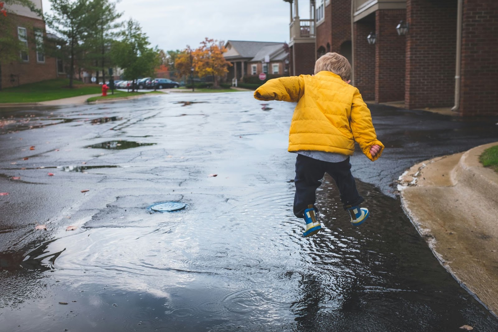 Photo of a child playing in puddles.
