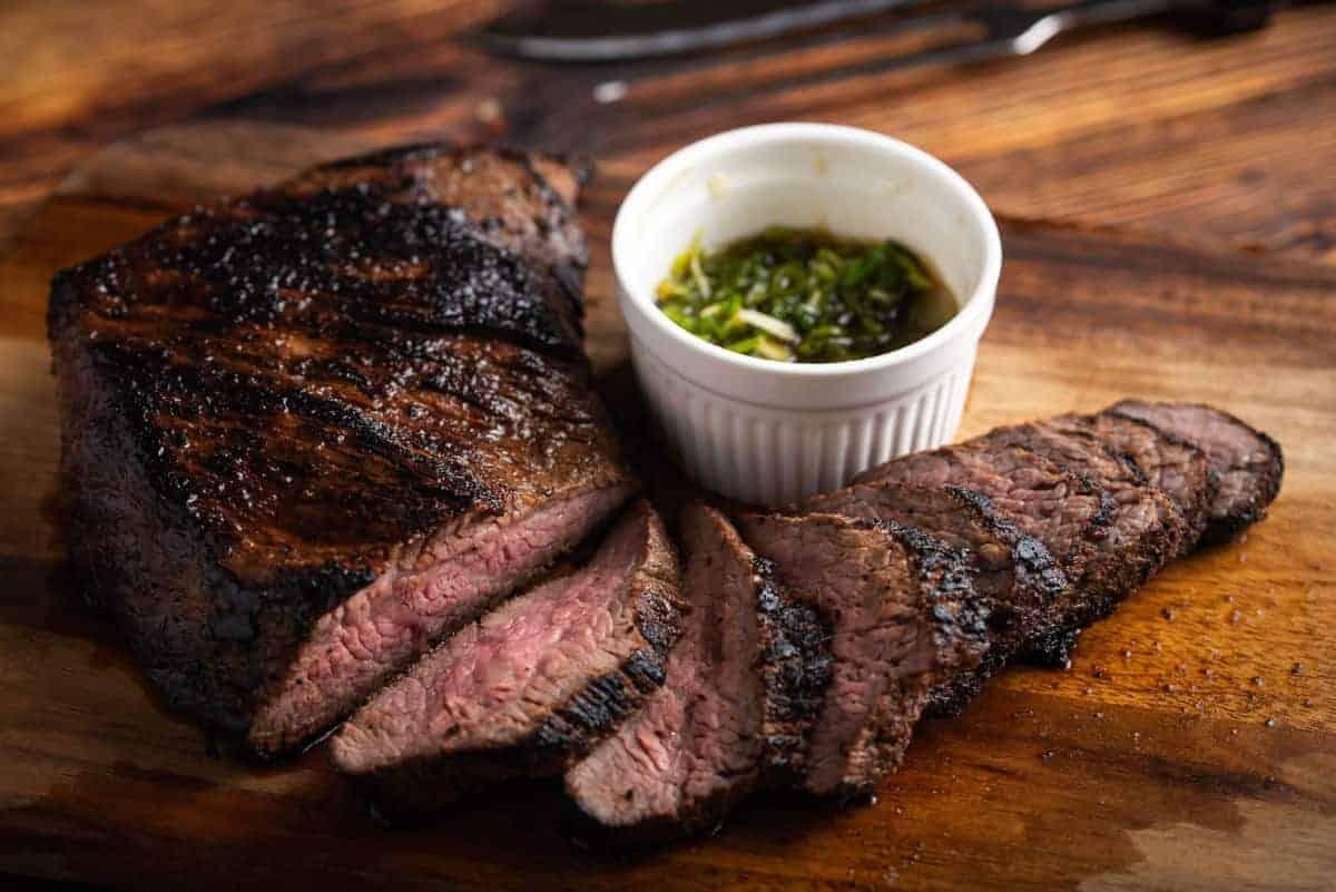 Un tri-tip afumat, apoi feliat cu un ramekin de chimichurri