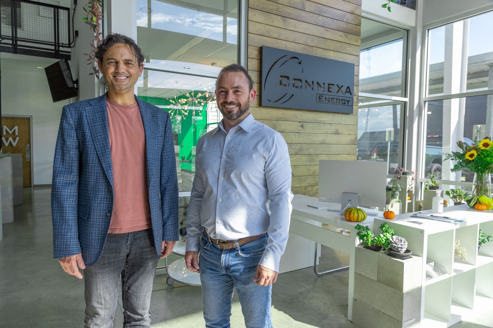CEO of Dragonfly Energy is smiling standing next to Michael Postel, Founder and President of Connexa Energy, who is standing and smiling. The two are standing in Connexa Energy's headquarters.