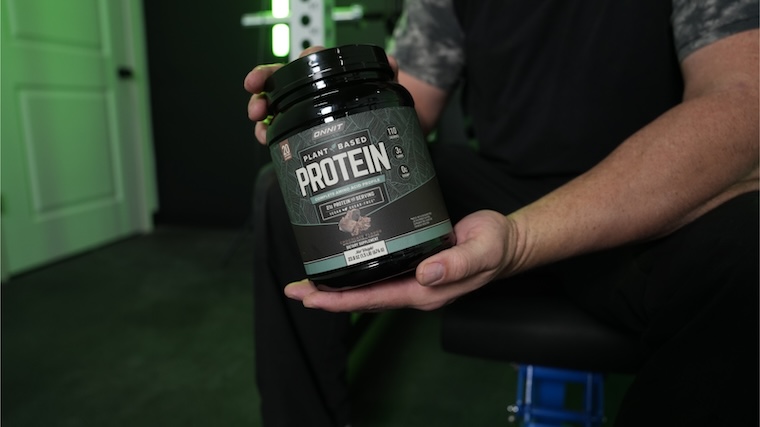 Our tester holding a container of Onnit Plant-Based Protein