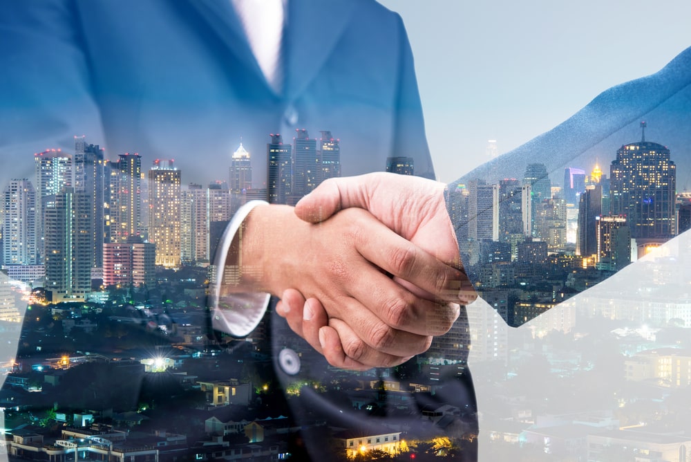 Double exposure of business handshake for successful of investment deal and city night background. Business for sale in Louisiana
