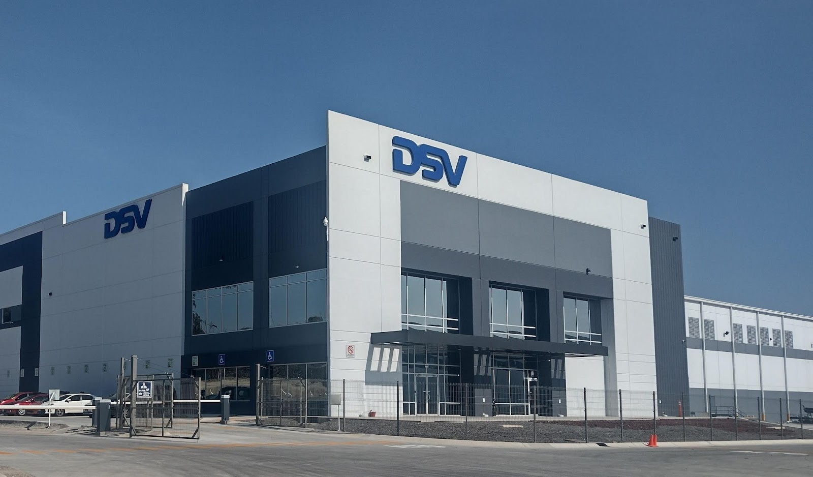 The outside of a fenced off DSV warehouse.
