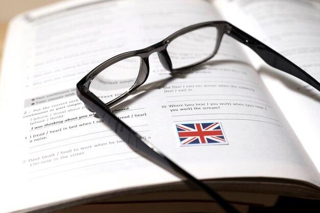Free photo english book with glasses on table