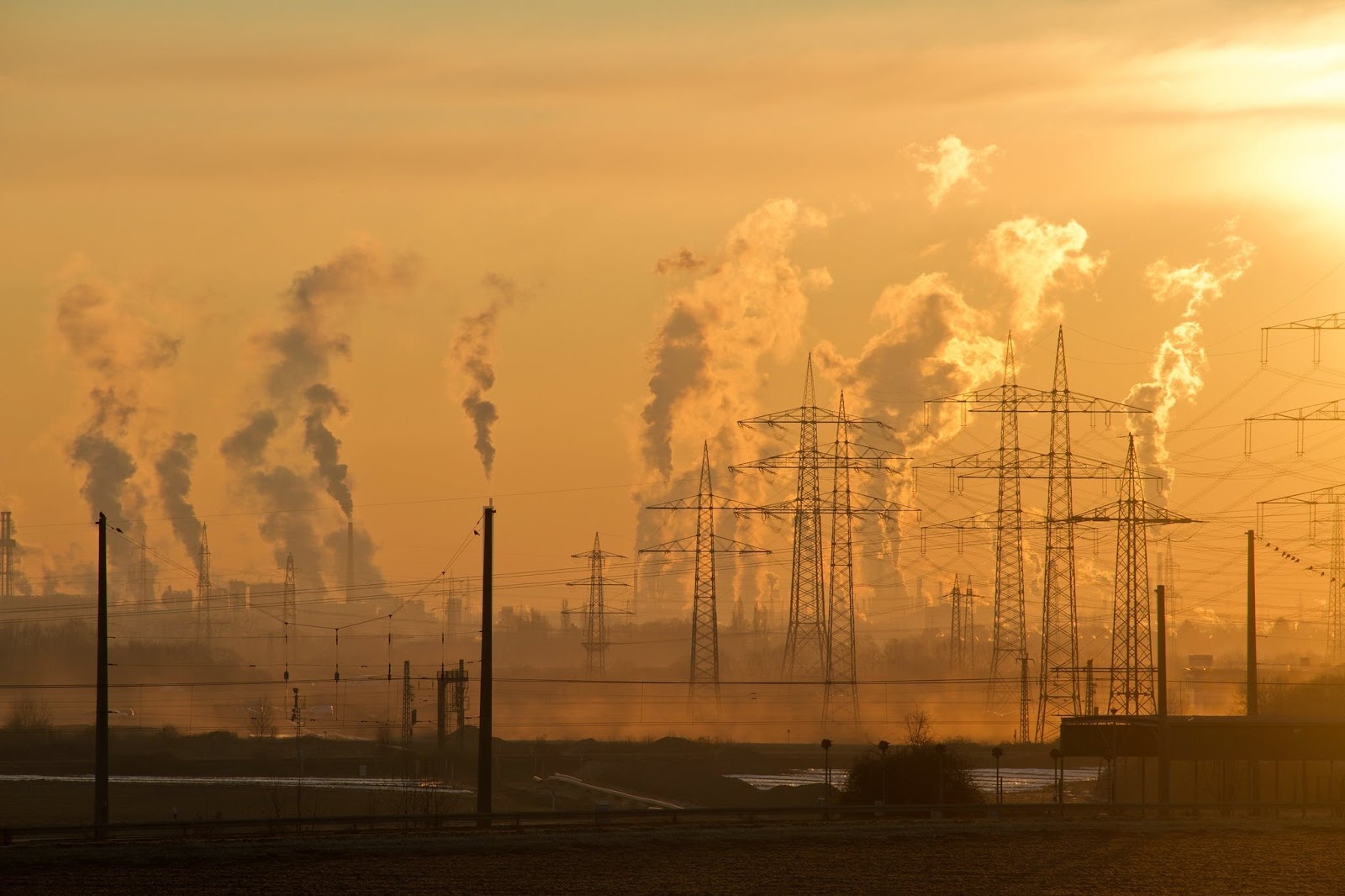 carbon emissions and pylons at sunrise which are being reduced as part of net zero initiatives