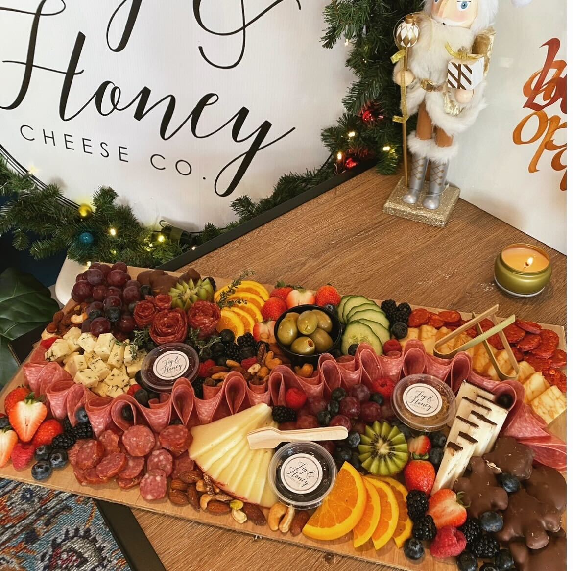 A charcuterie board array of different food organizes onto a table.