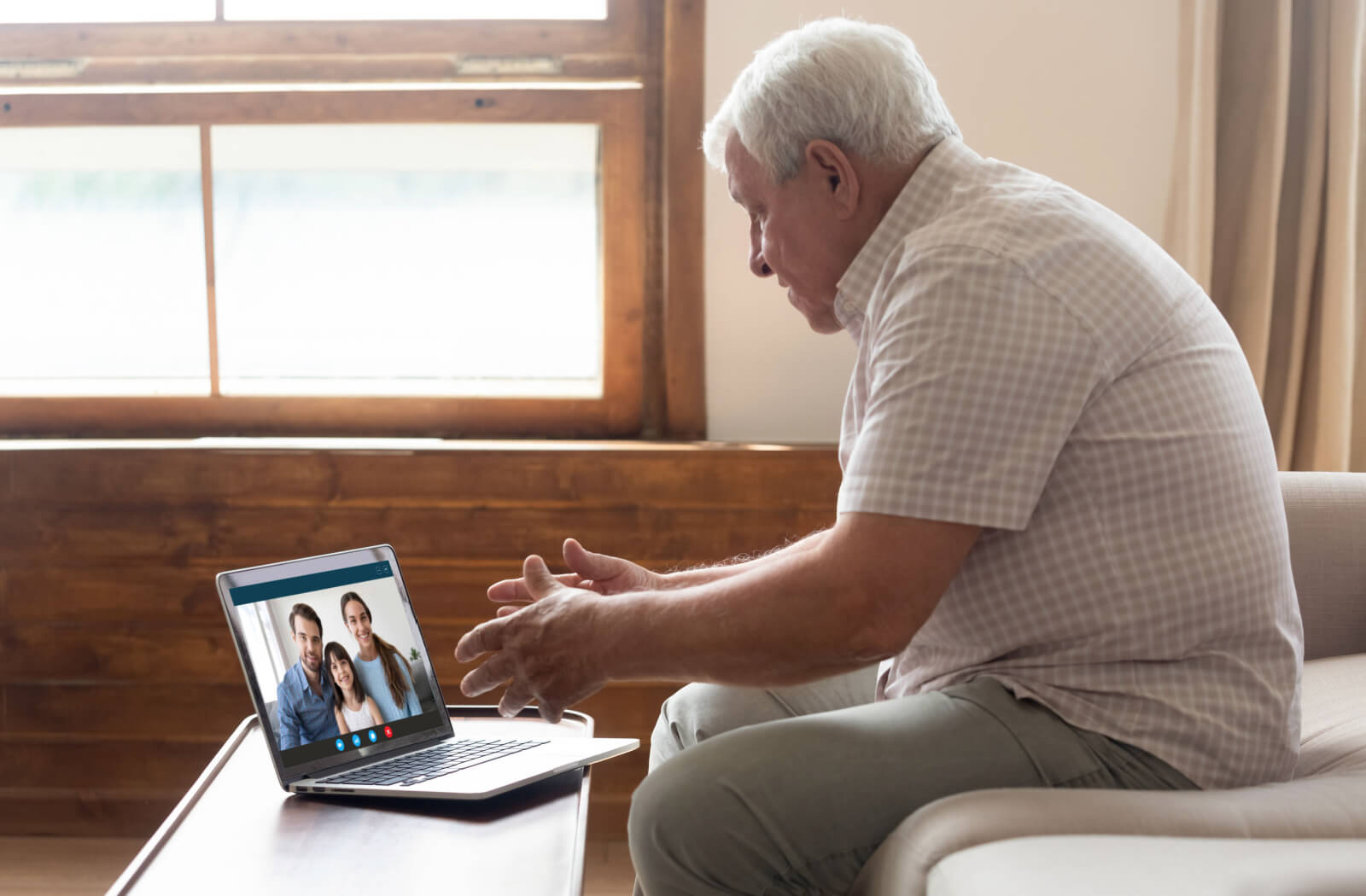 An older adult man on a video call with his family.