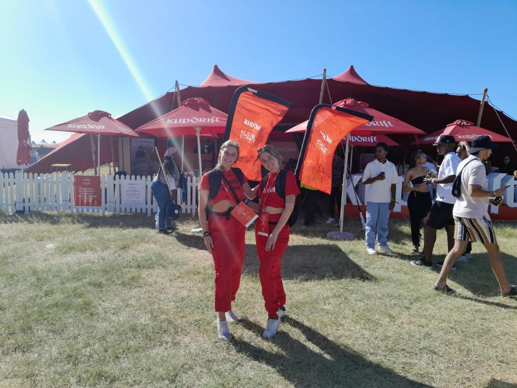 Two women standing in a field with flags

Description automatically generated