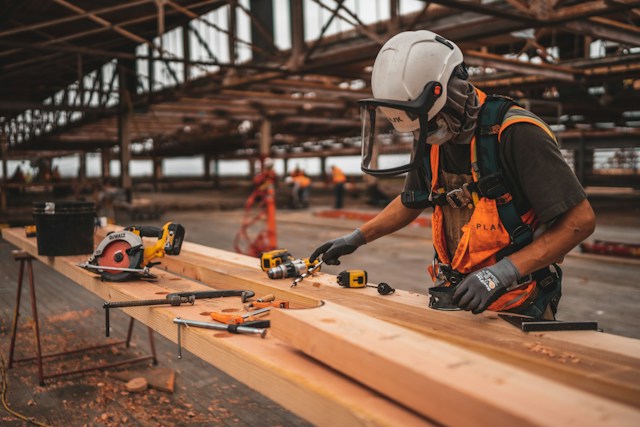 types of construction insurance - a carpenter polishing edges of a wood