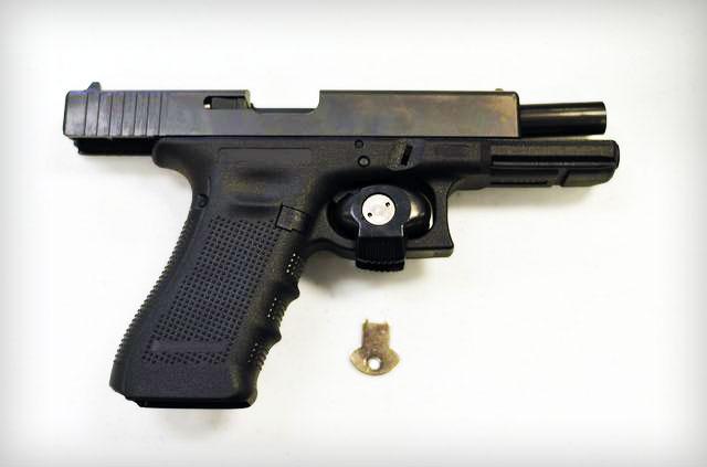 A black handgun with a key

Description automatically generated
