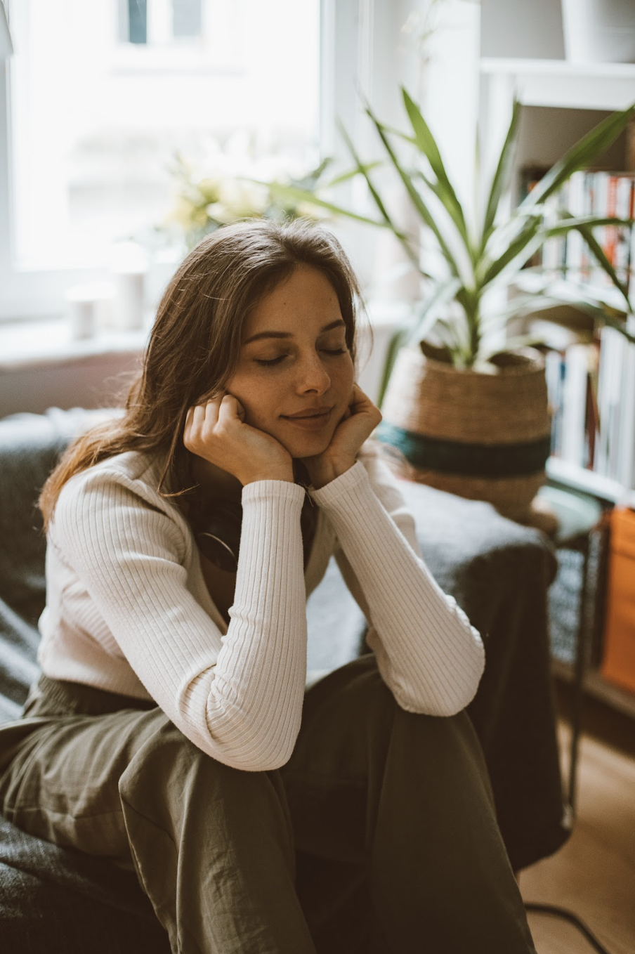 Woman sitting on a coach using mindful reflection to build her emotional resilience
