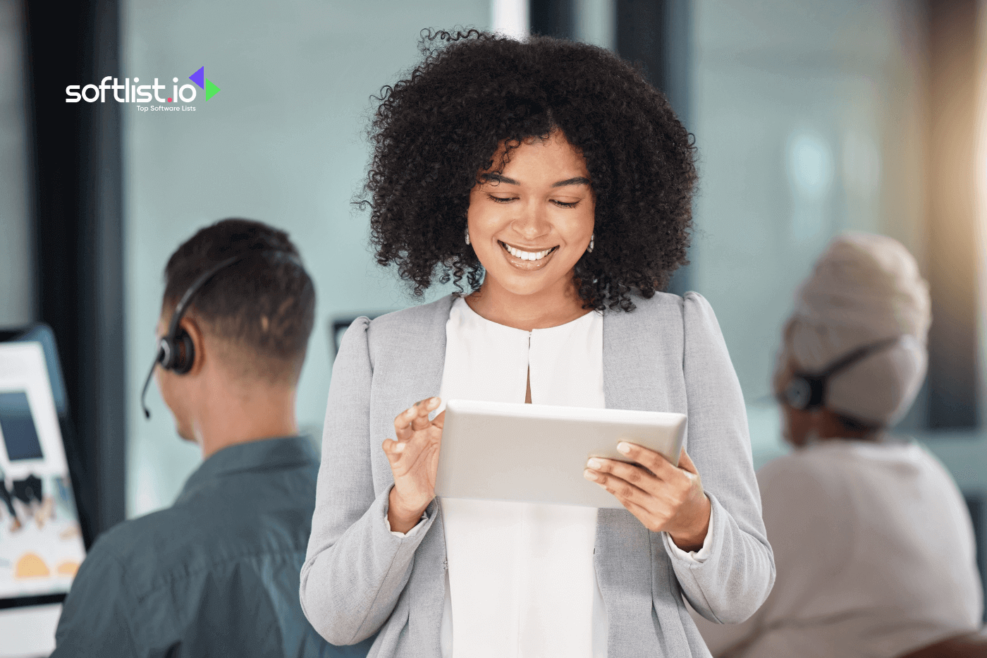 woman smiling while holding her tablet