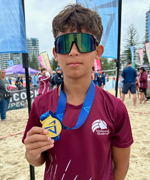 A child wearing sunglasses and holding a medal

Description automatically generated