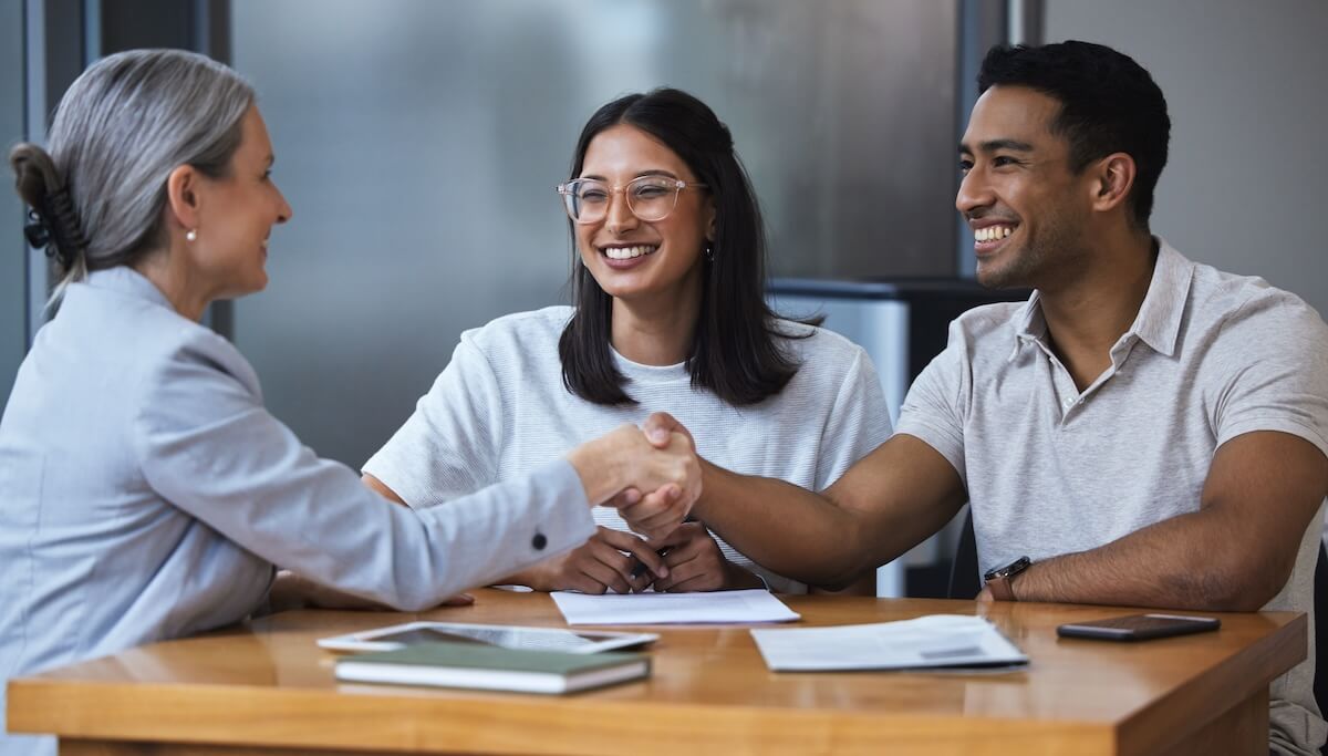 Improving patient experience: couple shaking hands with a doctor