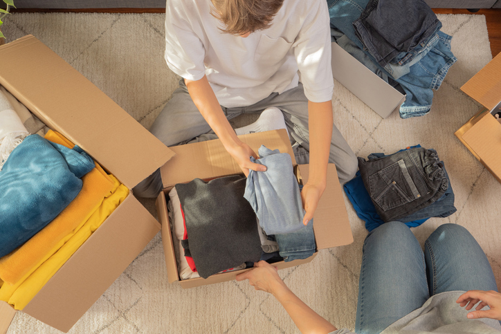 Students pack clothes in storage boxes and declutter. 