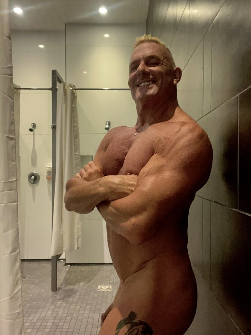 Matthew Figata posing naked and smiling in the gym locker room