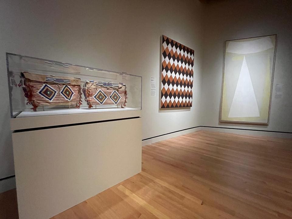 “Space Makers: Indigenous Expression and a New American Art” installation view at the Crystal Bridges Museum of American Art; left to right, Lakȟóta, artist once known, ca. 1880, Dyani White Hawk (Sicangu Lakota; b. 1976) 2019 painting, Will Barnet painting 1964-1965.