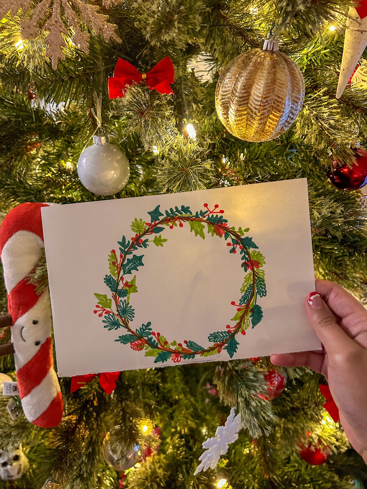 DIY Christmas Card Idea 2 is a very festive holiday wreath in a variety of colours.. The backdrop of the card is a well lit and decorated Chritmas tree.