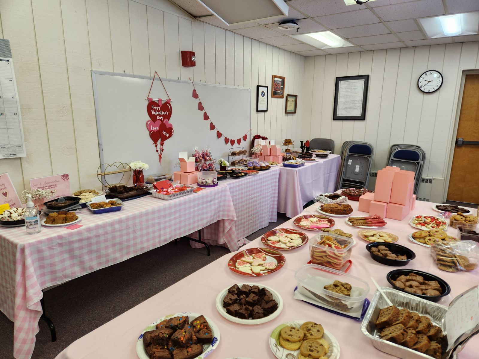 wide shot of tables setup with sweet treats for the staff for valentines day.