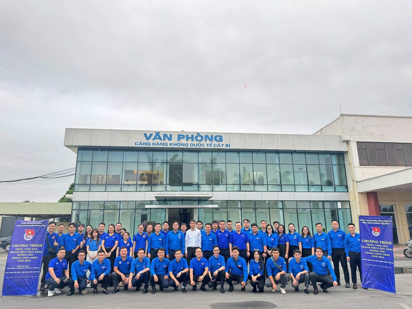 A group of people in blue shirts posing for a photoDescription automatically generated