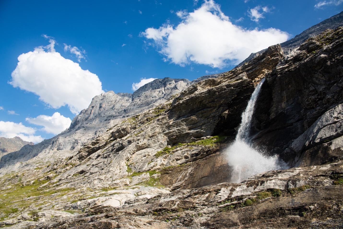 A waterfall falling from a rocky cliff

Description automatically generated