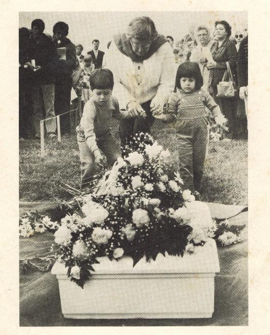 A person and children at a funeral Description automatically generated