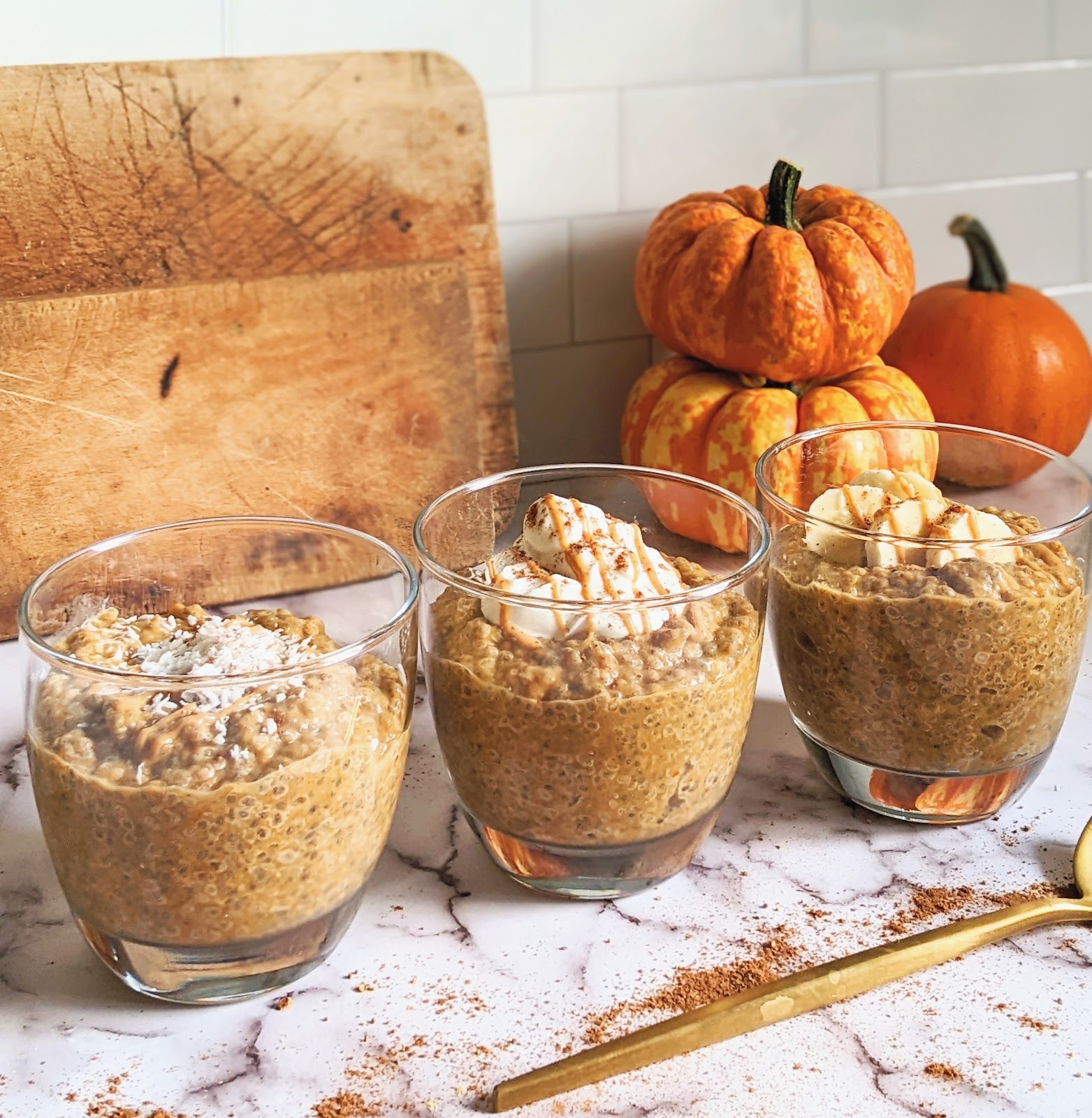 close up of pumpkin pie chia pudding in glass mugs with toppings