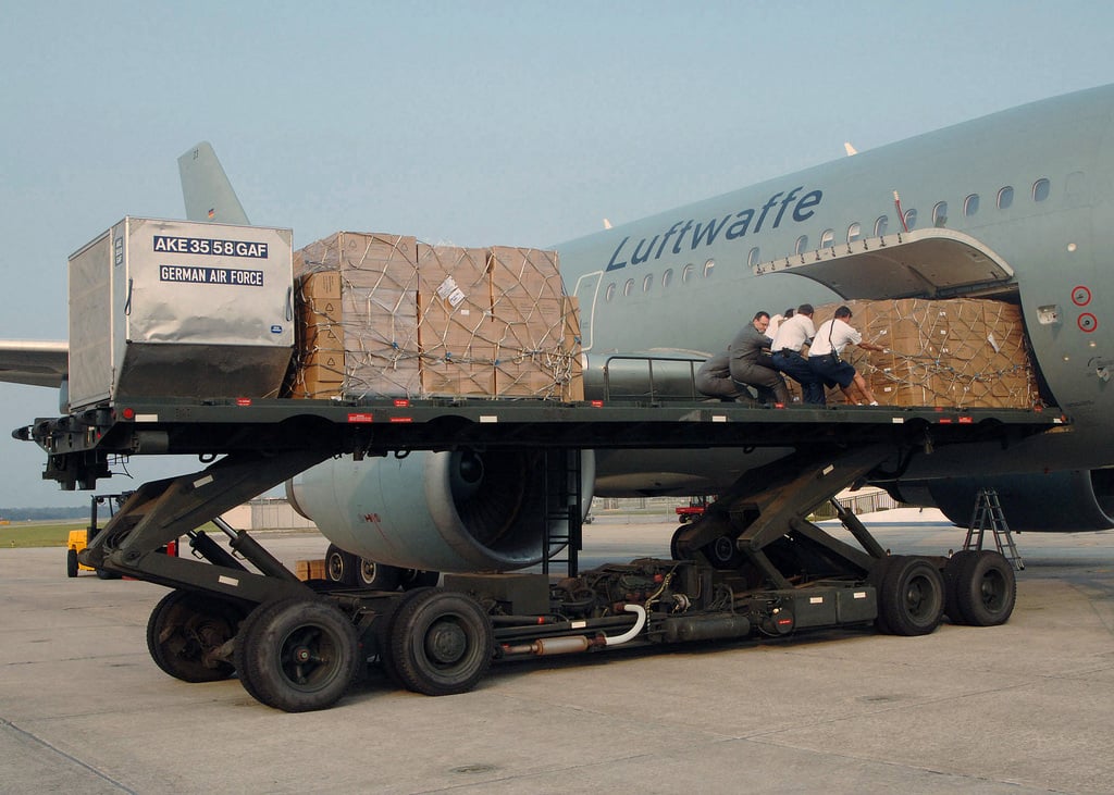 On this image, people are unloading cargo off the plane