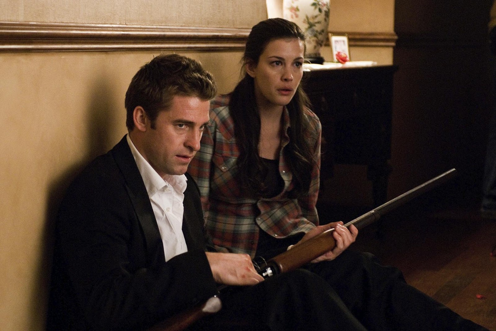 Liv Tyler y Scott Speedman en Los extraños de 2008. Scott está sosteniendo una escopeta