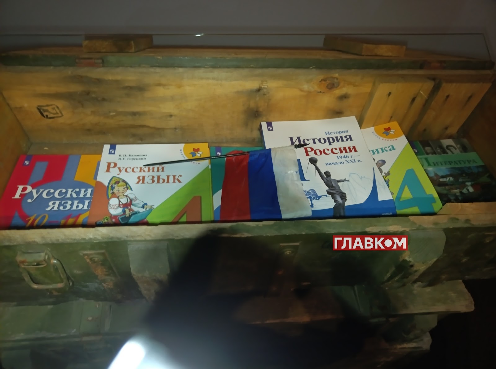 Російські підручники з окупованої частини Харківщини у 2022 року у ящику з-під снарядів символізують, що слова також є зброєю