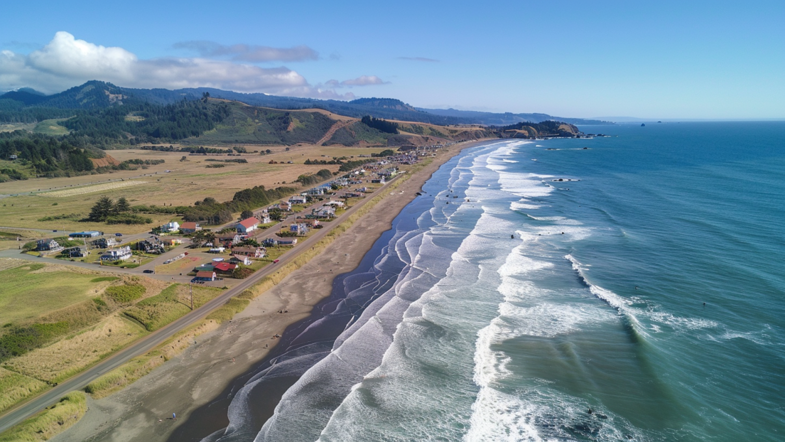 An aerial shot of Gold Beach, USA showing coastal homes and the mountains on the other side