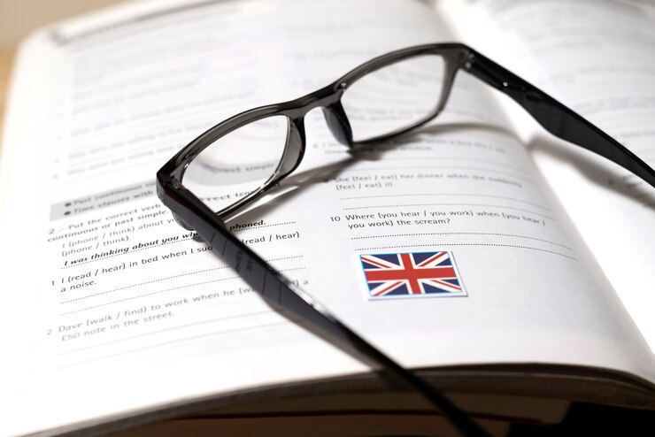 A-Level English Lit Essentials: a book on a table with glasses, representing focused study for success.
