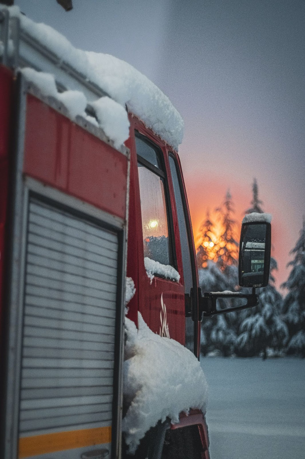 A picture of a snow-covered truck at sunrise
