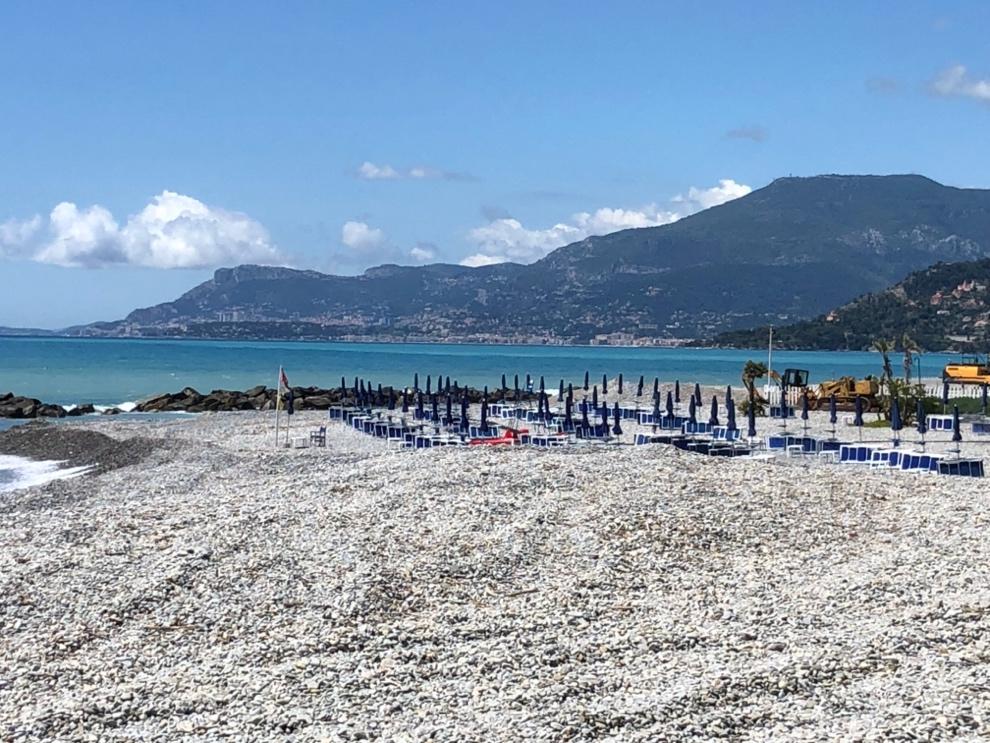 A beach with umbrellas and chairs

Description automatically generated