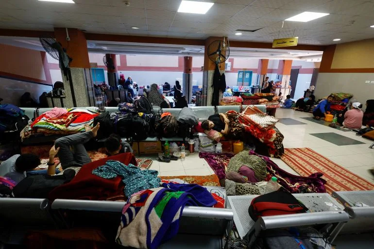 People sleep on hospital benches, carpets and tile floors inside the Nasser hospital.