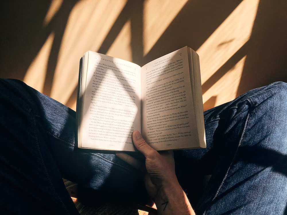 A Person is Reading Book in His Lap