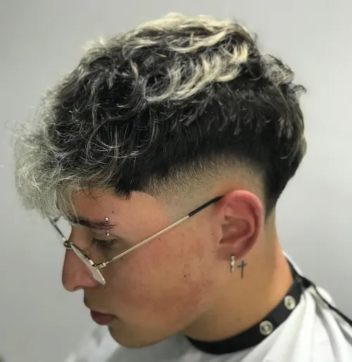 Picture showing a  guy wearing the low fade wavy edgar haircut
