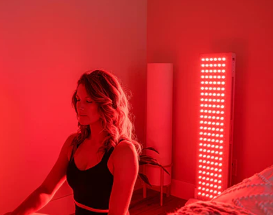 A person sitting in a room with red lights

Description automatically generated