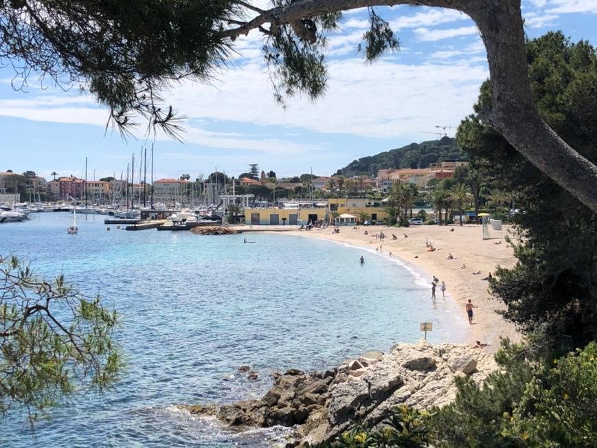 A beach with boats and buildings in the background

Description automatically generated