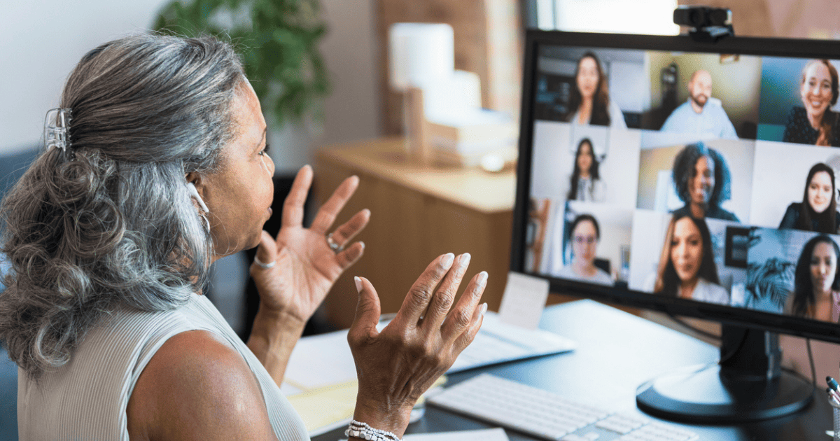 older woman speaking to employees on a video call 