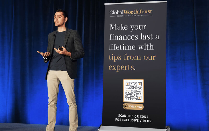 A QR Code placed on a banner during a conference talk connects customers to interactive information