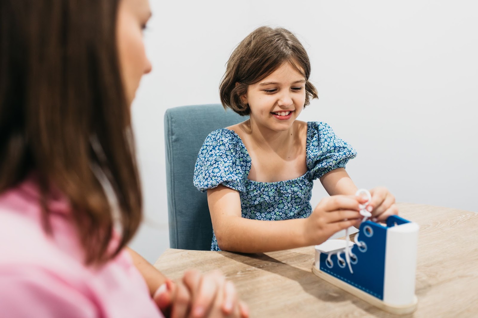 Child learning how to tie a shoe in an occupational therapy session